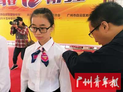 成人宣誓活动中,校长为学生佩戴成人logo。