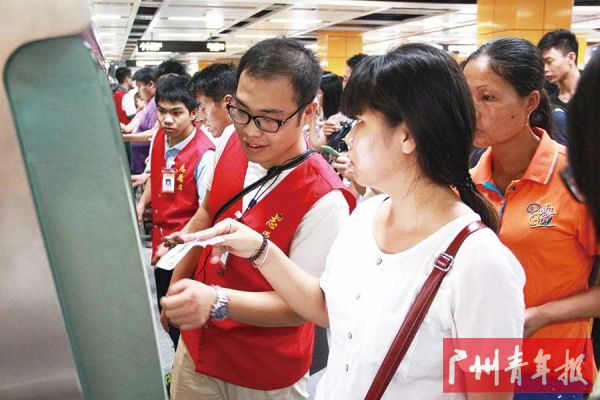 广州地铁团员志愿者为乘客服务。