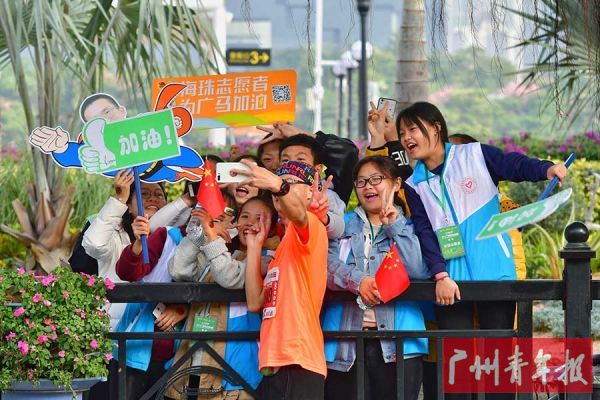 志愿者与沿途的选手合影。