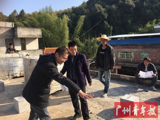 驻村干部正在与施工单位沟通太阳能光伏板安装。