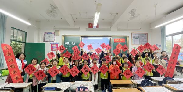 市少年宫书法老师梅莉在冬至前夕教乡村学校儿童写“福”字。 谢飞凡/摄