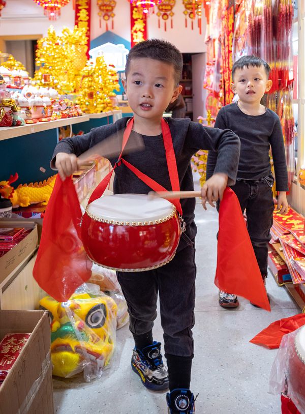 春节饰品店里,小朋友拿起红色的鼓敲打起来,当起“促售员”余兴东/摄