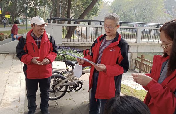 慕容燊林(左一)正与志愿者们一起巡河