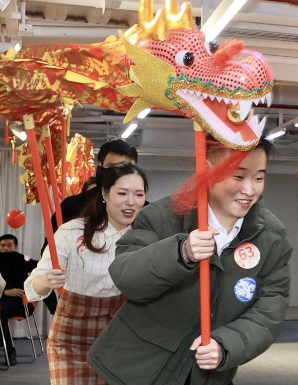 单身青年体验年味十足的“舞龙”游戏