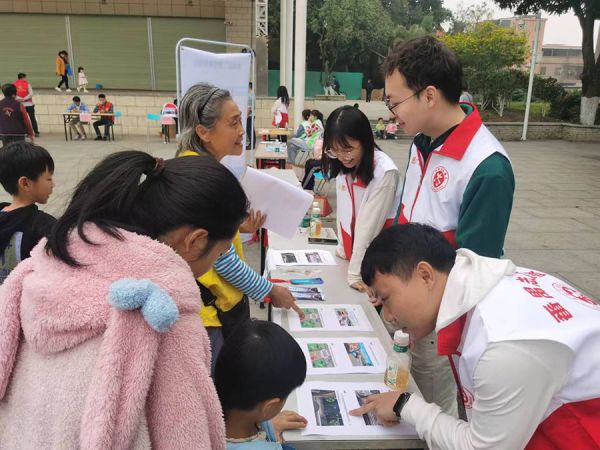 青年志愿者在化龙镇志愿服务集市为老人及青少年科普平安出行