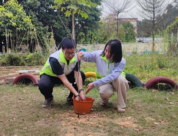 青年相互合作,一起为树苗浇水 李秋宇/摄