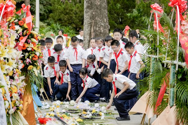 红领巾簇拥着来到花圈前为烈士送上鲜花
