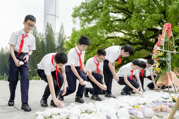 青年学生有序上前摆放鲜花,寄托哀思