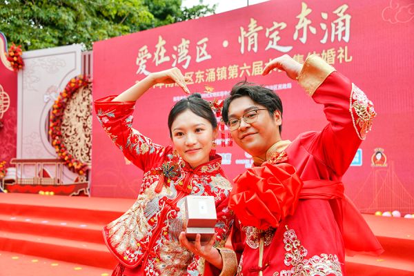 一对新人在集体婚礼上比心,定格“最美瞬间” 白洁/摄