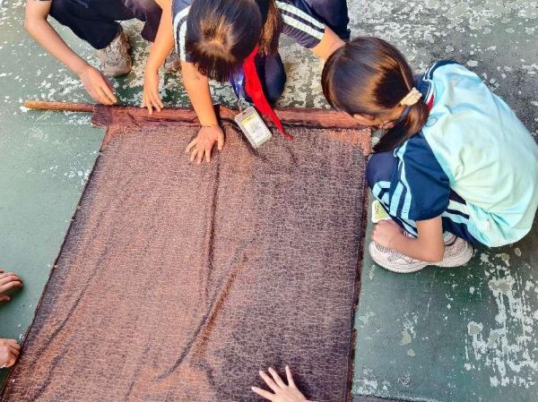 广州市南沙区顺平小学少先队员体验香云纱制作工艺。