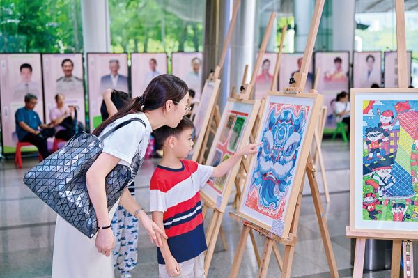 家长和孩子驻足欣赏美术作品