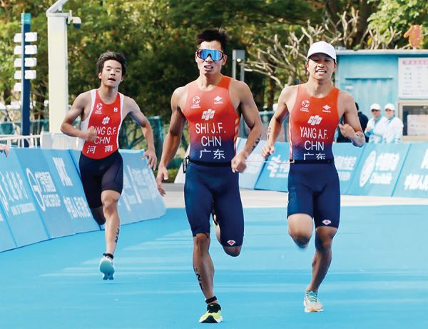 运动员石金飞(中)在铁人三项赛事中冲刺夺金