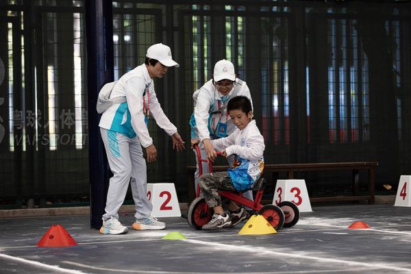 志愿者指导特殊儿童进行比赛