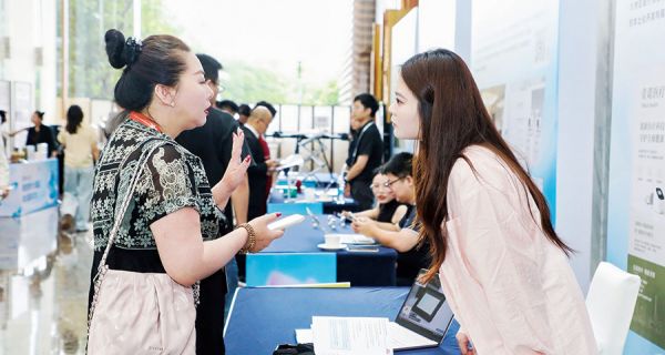 来宾与企业代表在青创摊位上细致交流