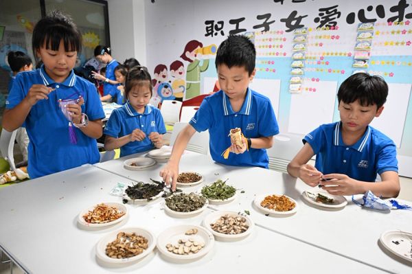 花都区“共青团・伙伴计划”快递物流园区爱心托管班学员体验中医香囊制作