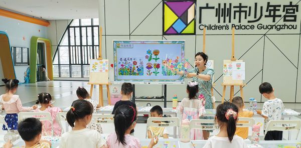 市少年宫老师在创意艺术工作坊上带着孩子们一起创作