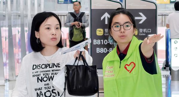 志愿者在交通枢纽为市民游客指引路线