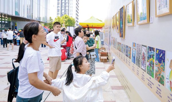 市民驻足观赏特殊孩子创作的书画艺术作品